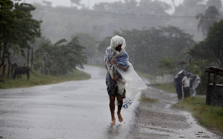 24hours: A man walks through wind and rain brought by Tropical Storm Paula