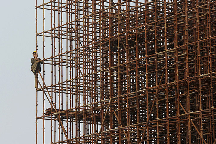 24hours: A worker stands on scaffoldings at a construction site in Hefei