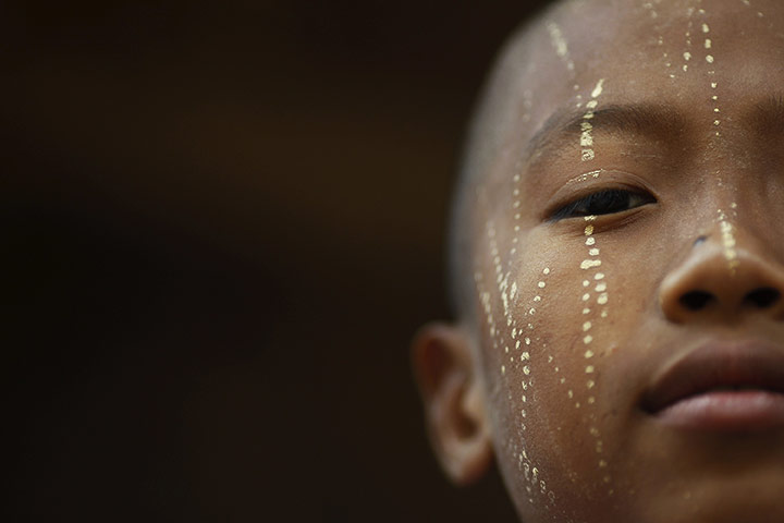 24 Hours in Pictures: A child of migrant workers with thanaka paste on his face in Thailand 