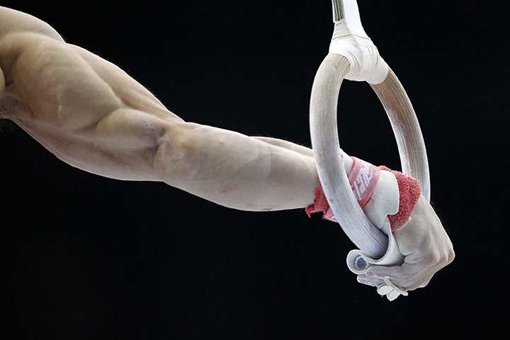 24 Hours in Pictures: A gymnast of China performs on the rings during the men's training session