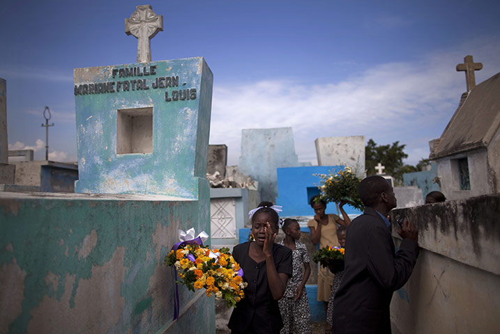 24 hours in pictures: Port-au-Prince, Haiti: a child at the funeral of her mother at a cemetery