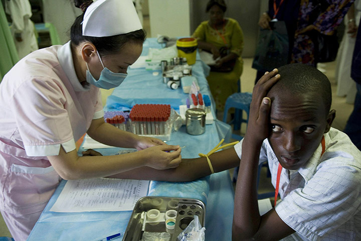 24 hours in pictures: Mombasa, Kenya: A Chinese nurse takes blood from a Kenyan teenager 