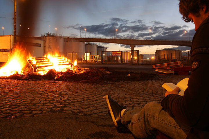 Fuel shortages in France: A striker reads a book as they block fuel storage depots in Caen
