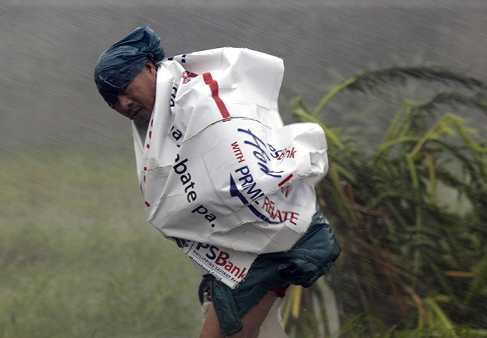 typoon: A villager manuevers against Typhoon Megi's strong winds and rains