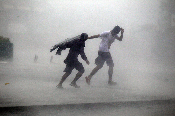 typoon: Villagers make their way through typhoon Megi's strong winds and rain