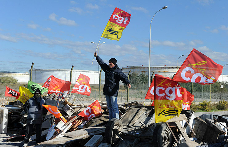 Fuel shortages in France: A striker holds a CGT union flag as strikers block fuel storage depots