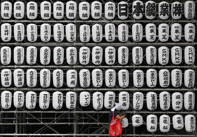 24 hours: Tokyo, Japan: A worker sets up lanterns 