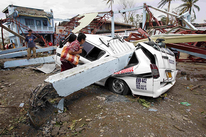 Typhoon Megi : Residents inspect a car damaged after Typhoon Megi hit the town of Ilagan