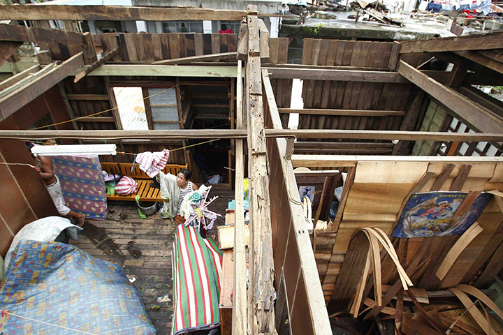 Typhoon Megi : A resident dries clothes in her house after the roof blew off in Ilagan
