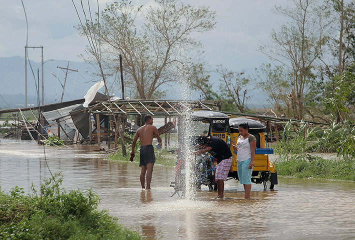 Typhoon Megi : Residents attempt to fix their damaged vehicles in floodwater in Tuguegarao