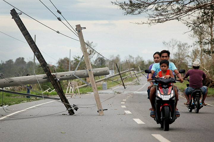 Typhoon Megi : People drive past downed power poles felled by Typhoon Megi in San Jose