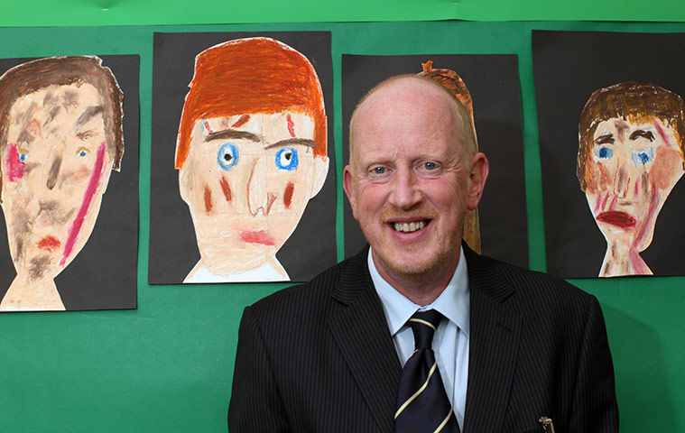 Teaching Awards 2010: A man smiles in front of children's paintings