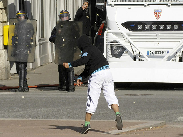 France Strike Update: A young man throws a stone against anti riot police Lyon France