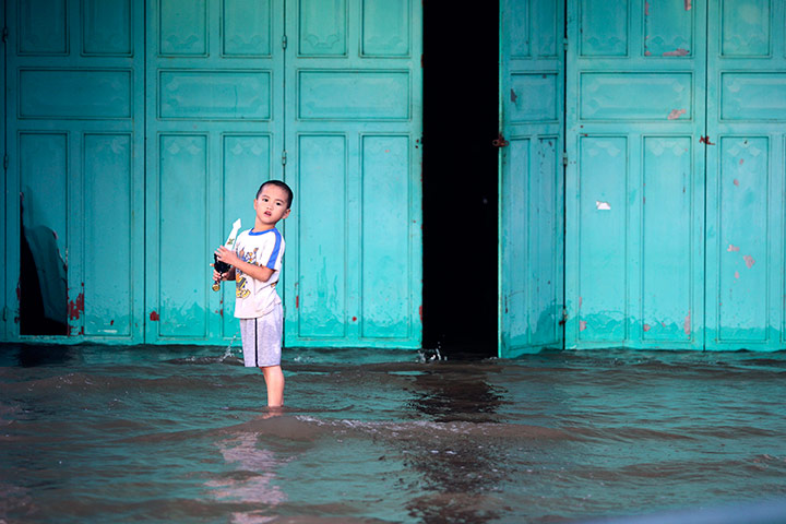 24 hours: A boy plays in front of his flooded house in downtown of Ha Tinh city