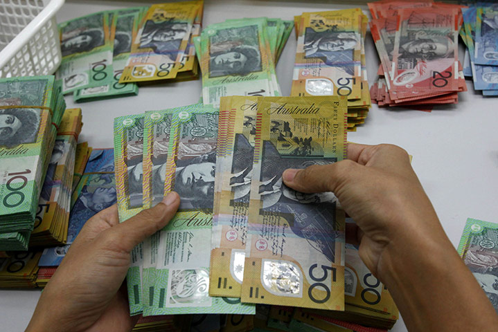 Week in Business: A bank employee counts Australian bills at Kasikornbank in Bangkok