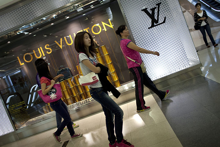 Week in Business: Women walk past a Louis Vuitton store at a shopping centre in Beijing