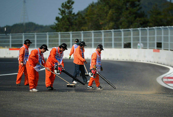 Korean Grand Prix: Marshalls clear debris from the final corner between practice sessions