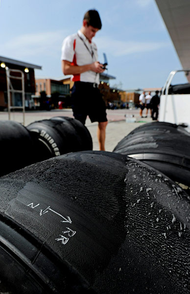 Korean Grand Prix: An engineer checks tyres after the first practice session