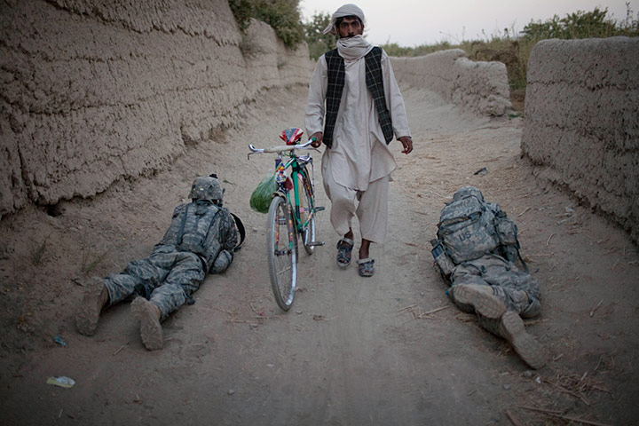 24 hours: An Afghan villager walks among US  soldiers