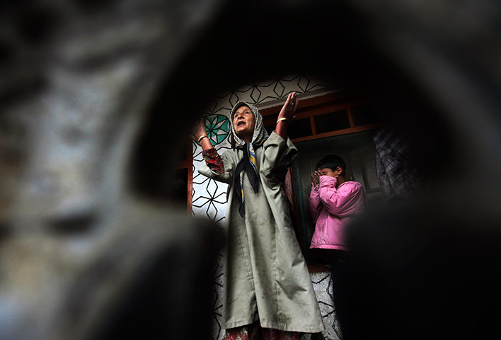 24 hours: A Kashmiri woman wails inside her partially damaged house after a gunbattle