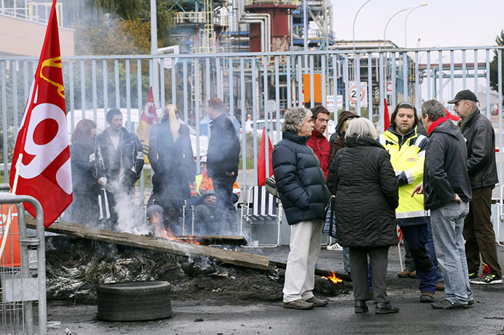 french strikes: Strikers stand near a burning barricade