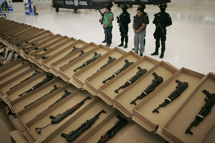 24 Hours in Pictures: Weapons found hidden in a horse trailer are shown to the press in Mexico