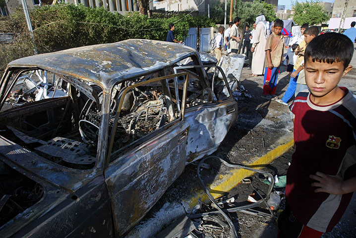 A Day in Iraq: Iraqis gather around the site where two car bombs killed 20 people