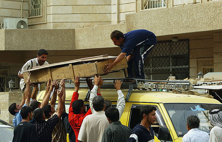 A Day in Iraq: Iraqis carry the body of a relative at the morgue of al-Yarmouk hospital