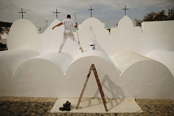 24 hours: Casabermeja, Spain: A man paints a tombstone in a cemetery
