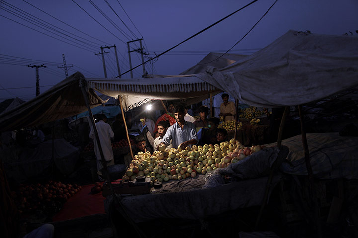 24 hours: Rawalpindi, Pakistan: A fruit vendor arranges his apples at a market