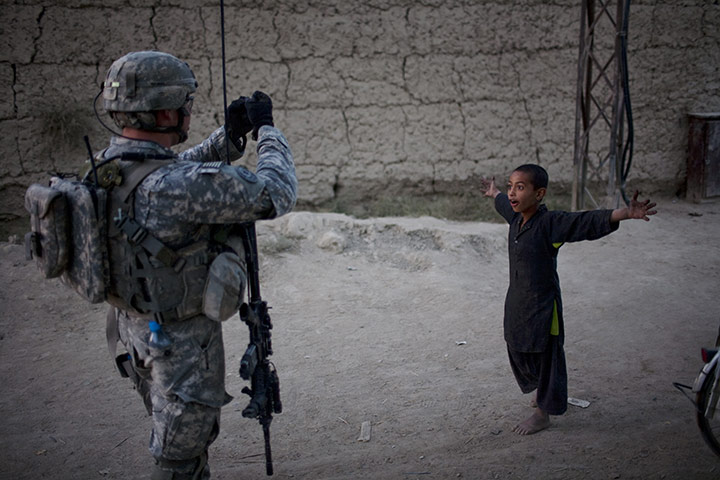 24 hours: Kandahar, Afghanistan: A boy reacts as a US soldier takes his picture