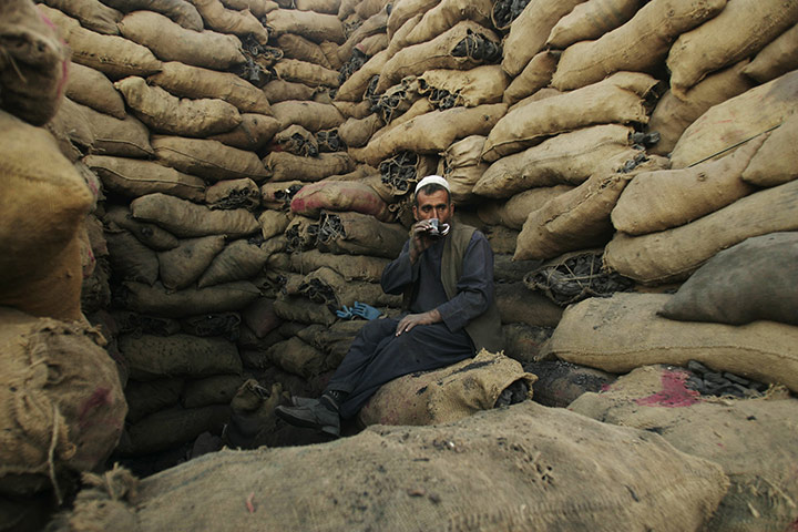 24 hours: A coal seller drinks tea as he waits for customers in Herat