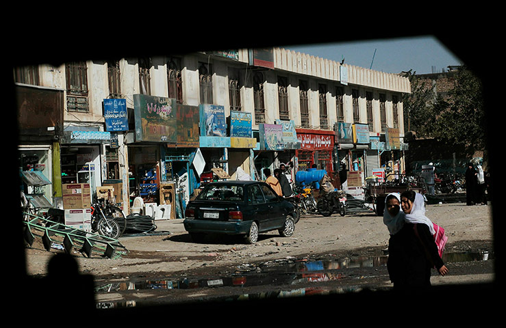 From the agencies: Schoolgirls walking home from classes and others are seen through a Humvee 