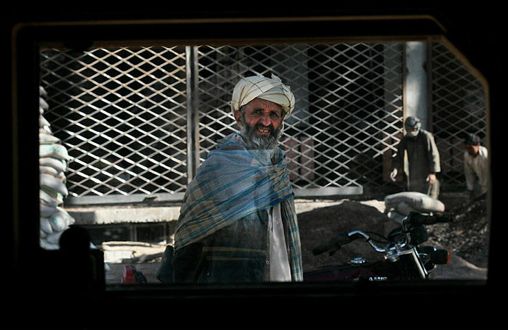 From the agencies: An Afghan man stares back through the window of a US Army Humvee
