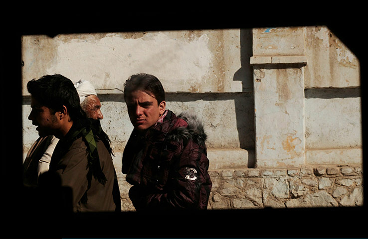 From the agencies: Men riding a motorcycle are seen through the window of a US Army Humvee 