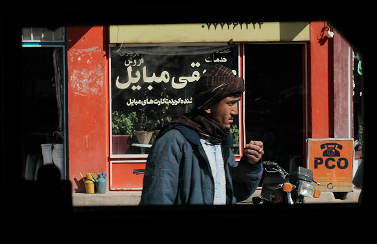 From the agencies: A man walking the streets is seen through the window of a US Army Humvee 