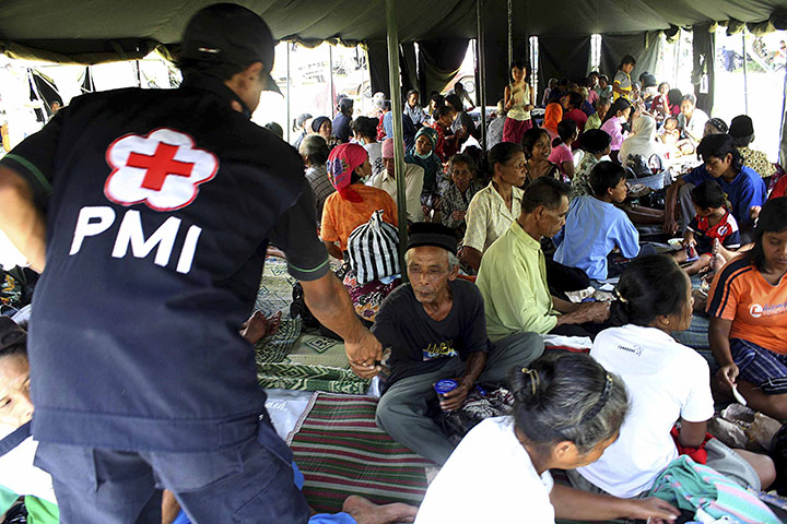 Indonesia Update: An Indonesian Red Cross volunteer distributes drinking water Indonesia