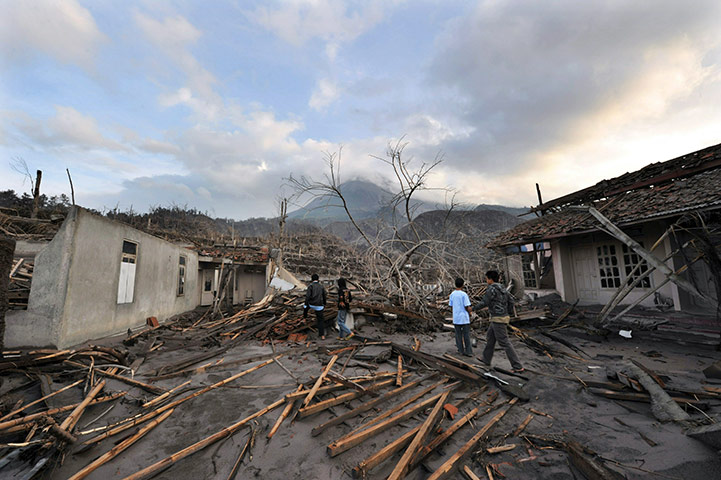 Indonesia Update: Residents examine devastated houses as Merapi smokes behind,  Indonesia