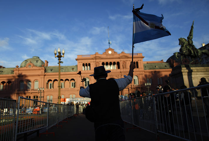 24 Hours In Pictures: A man dressed in a Gaucho outfit holds an Argentine flag