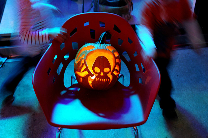 24 Hours In Pictures: Children run around a freshly carved pumpkin, Halloween