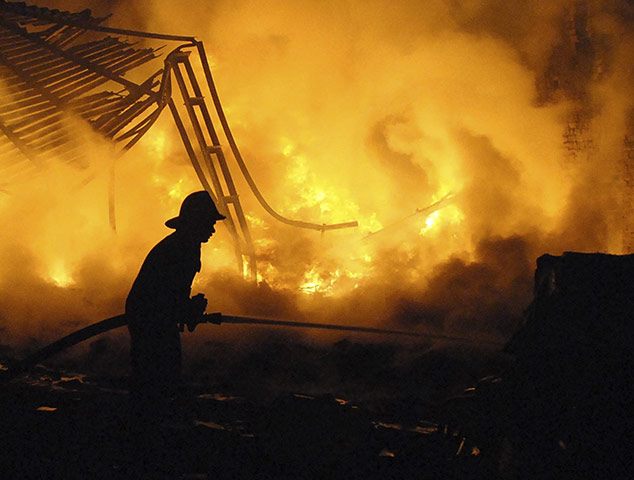 24 Hours In Pictures: A firefighter extinguishes fire from a textile processing unit Ahmedabad