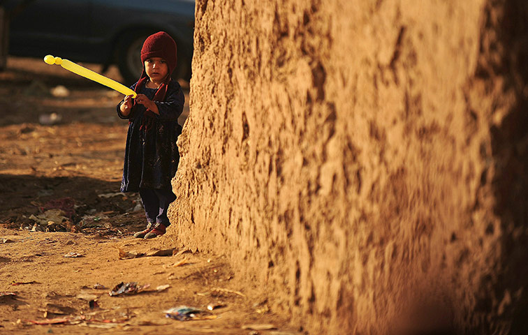 24 Hours In Pictures: A boy plays with a balloon in a slum are