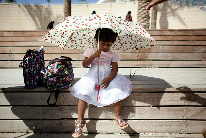 24 hours in pics: A Christian pilgrim girl sits by the Jordan River