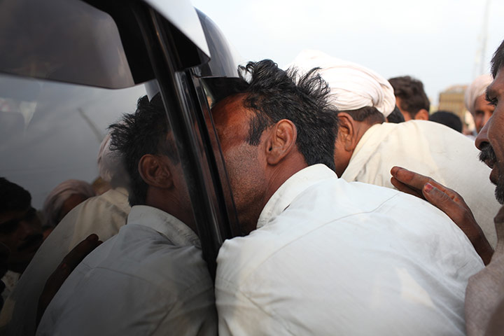 Pakistan floods- Punjab: A desperate flood affectee crowds into the car of Jamshed Dasti,