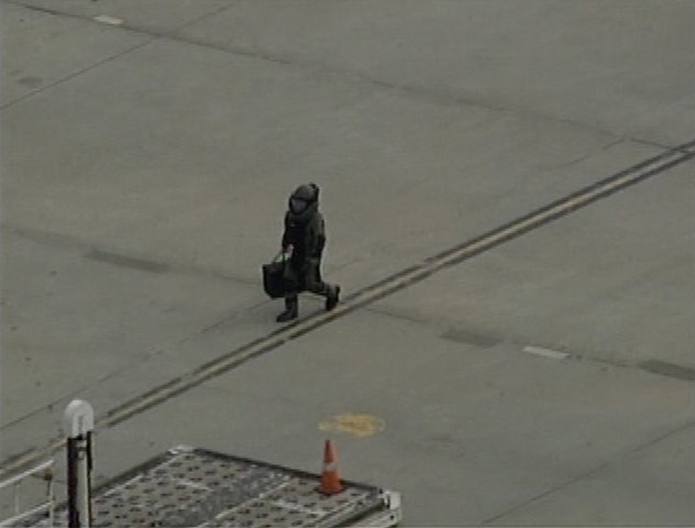 Cargo Terror: A bomb squad officer carries a package away from a UPS plane in Newark