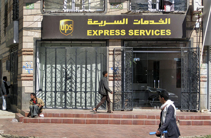 Cargo Terror: Yemenis walk past the UPS office in the capital San'a