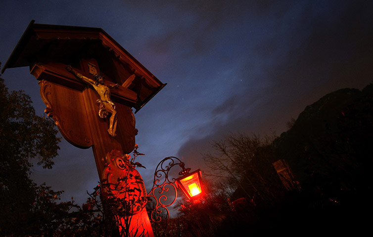 24 hours in pictures: Innsbruck, Austria: A wooden cross is illuminated at dusk 