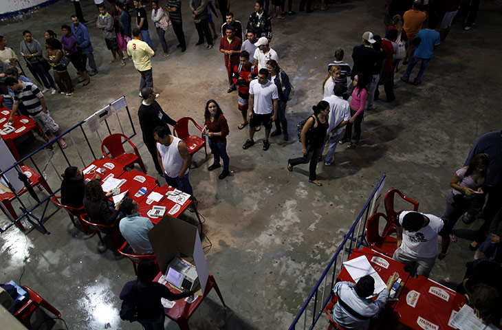 Brazil elections: People stand in line to vote in a polling station in the Rocinha slum