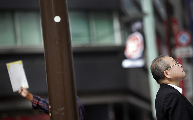 24 hours in pictures: Tokyo, Japan: A man waits at a crossing