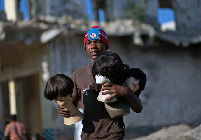 24 hours in pictures: Port-au-Prince, Haiti man carrying mannequin heads